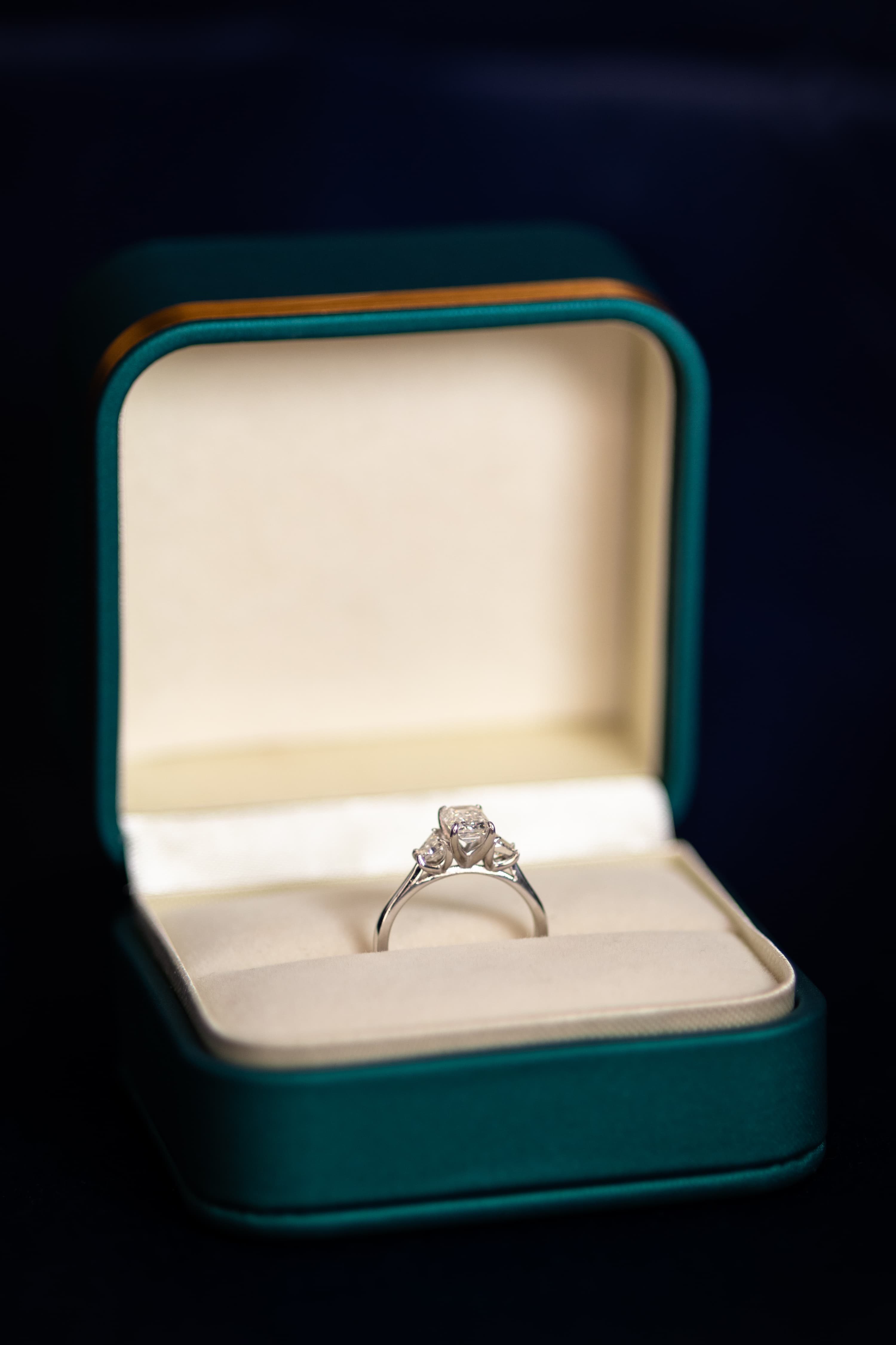 A yellow gold diamond engagement ring nestled in a soft cream-lined ring box