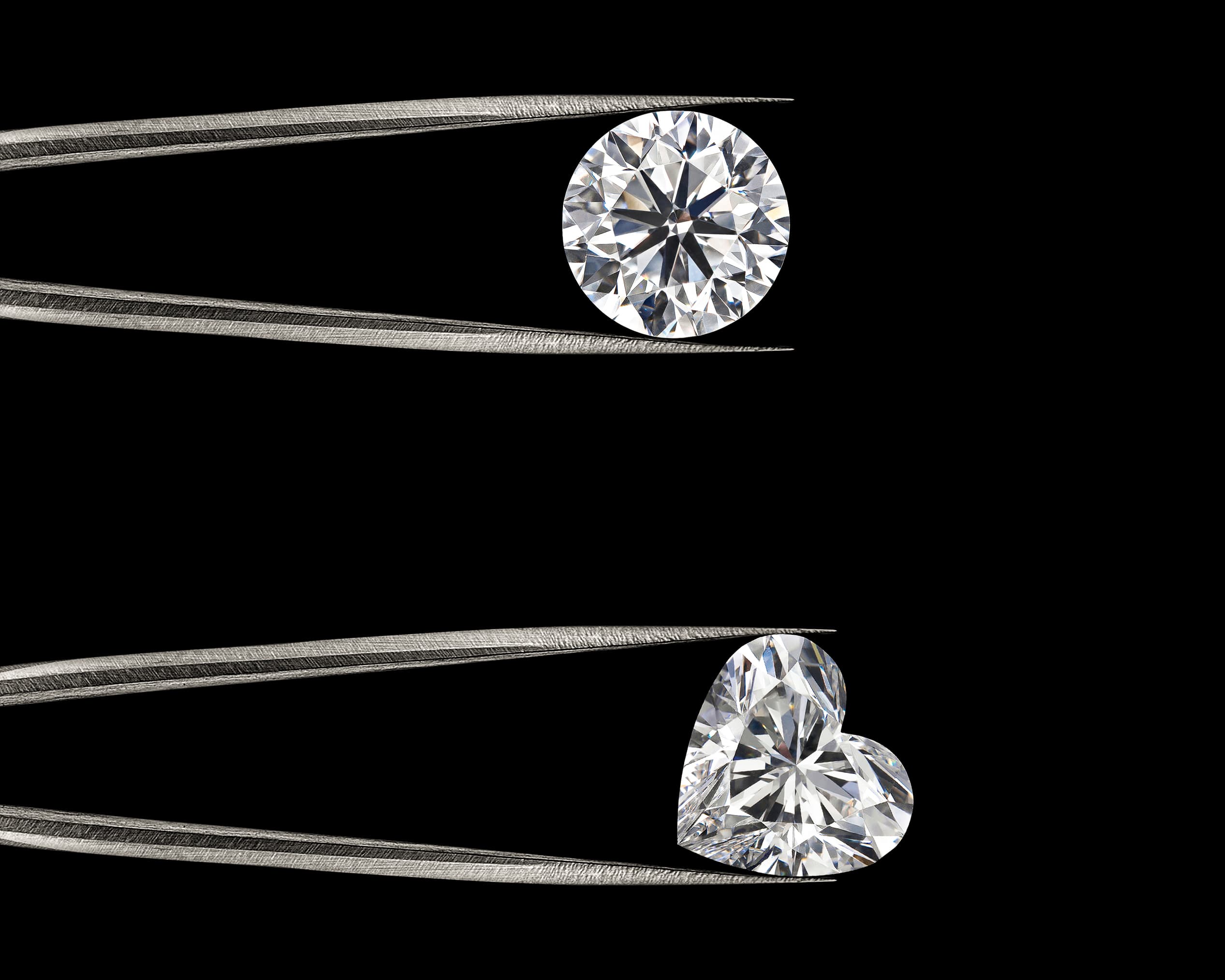 A colourless round brilliant diamond held in tweezers beside a brass jeweller's loupe, loose diamonds and a grading card on navy linen, illustrating the 4Cs of diamond quality