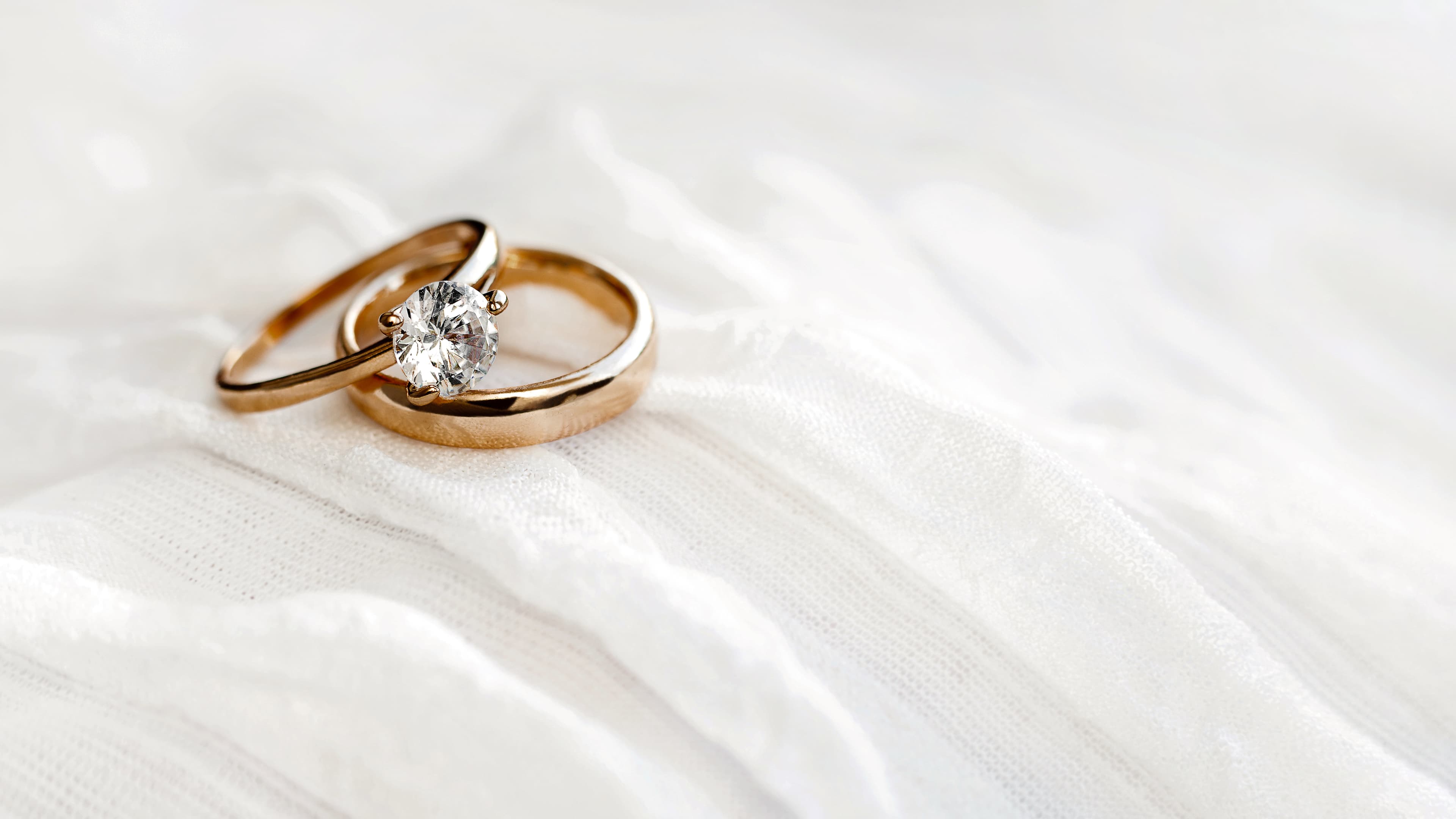 A gently curved contoured yellow gold wedding band shaped to sit flush against an engagement ring